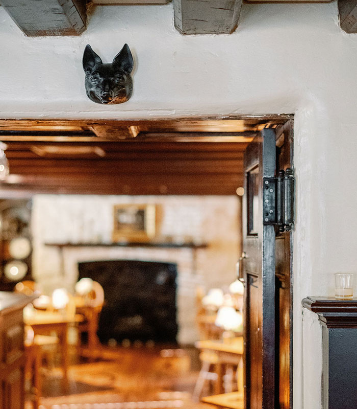 Entrance to a cozy rustic restaurant with a wooden door and warm interior lighting